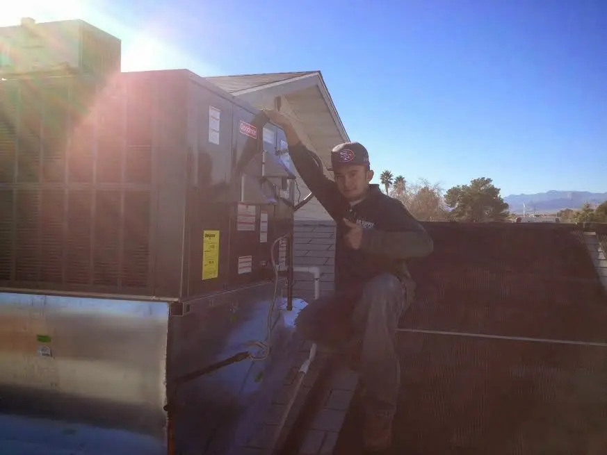 HVAC technician performing HVAC Inspection on a rooftop unit in La Crescent